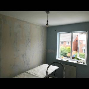 A bedroom before having fresh wallpaper applied