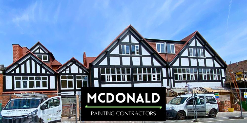 Company vans and painters painting tudor style buildings